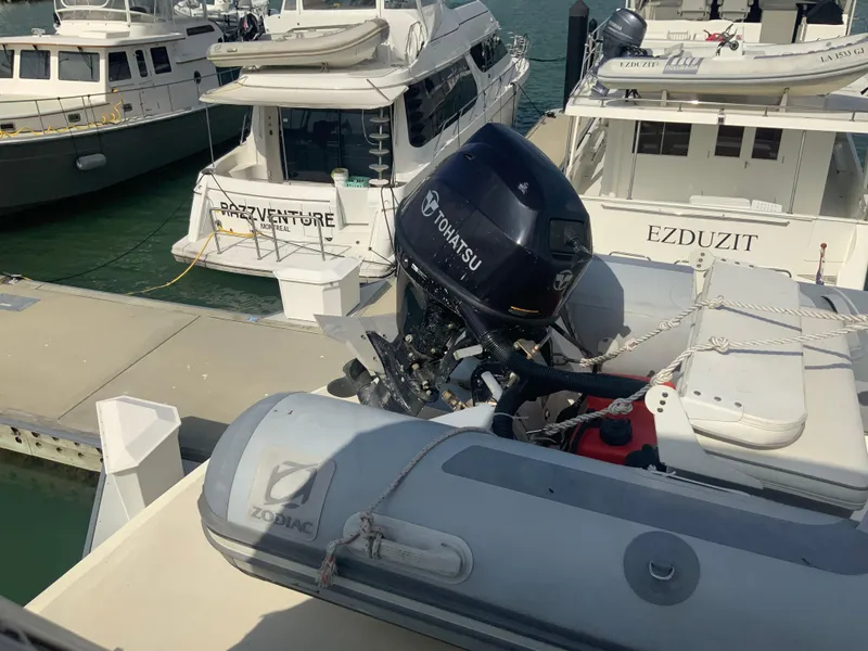 Slide: The Image of A 1979 Hatteras 53 Motor Yacht docked with a Zodiac inflatable boat and Tohatsu outboard motor. - 18