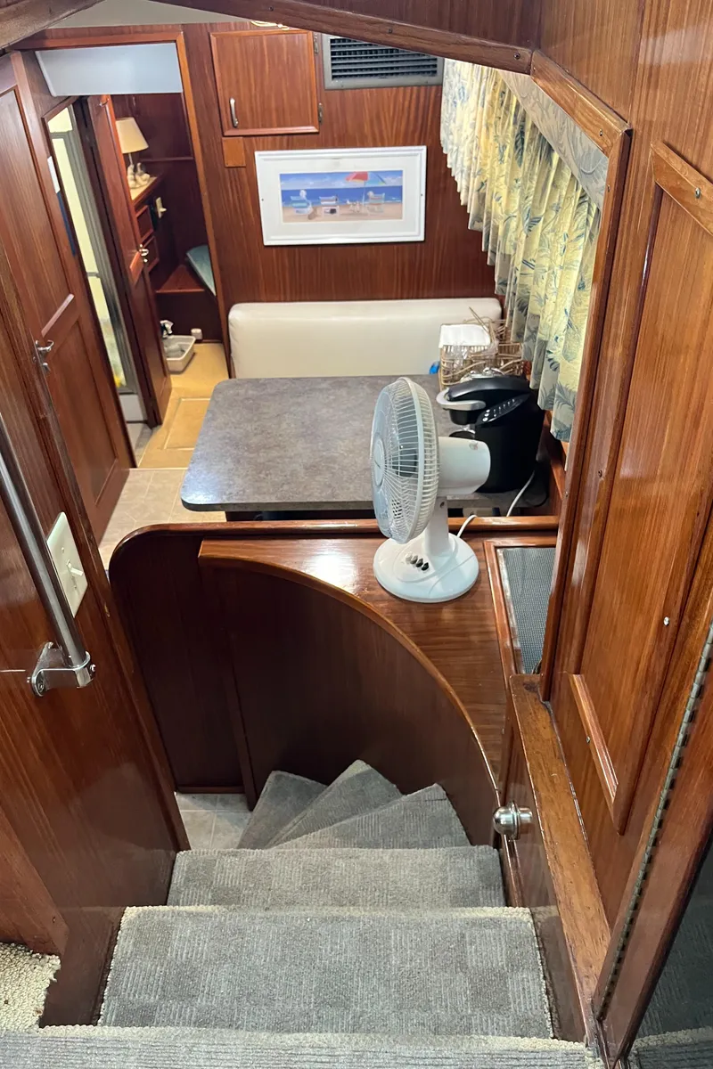 Slide: The Image of 1979 Hatteras 53 Motor Yacht interior with stairs, table, and fan. - 26