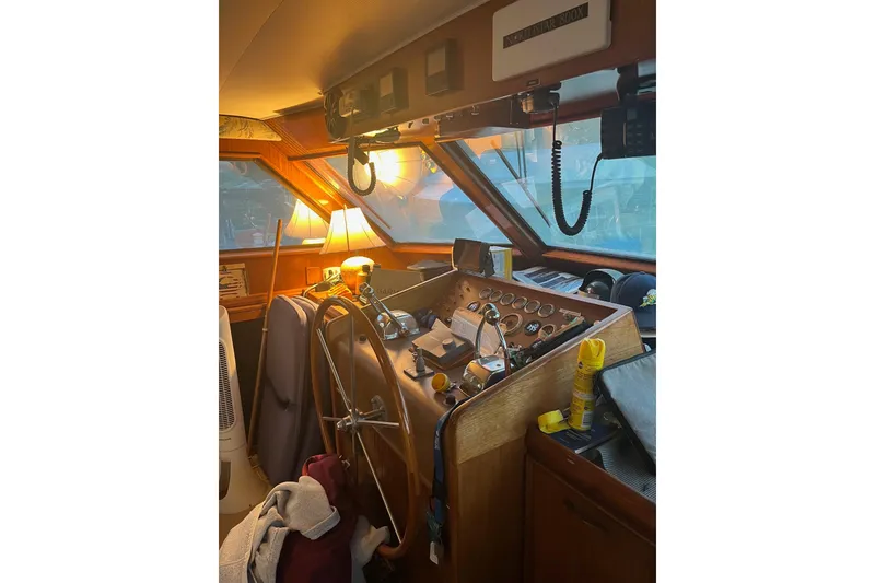 Slide: The Image of 1979 Hatteras 53 Motor Yacht helm with wooden wheel, gauges, and nautical equipment. - 33