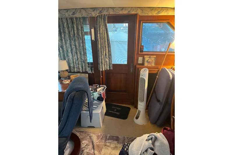 Slide: The Image of Interior of 1979 Hatteras 53 Motor Yacht with wooden door, fan, and nautical decor. - 34