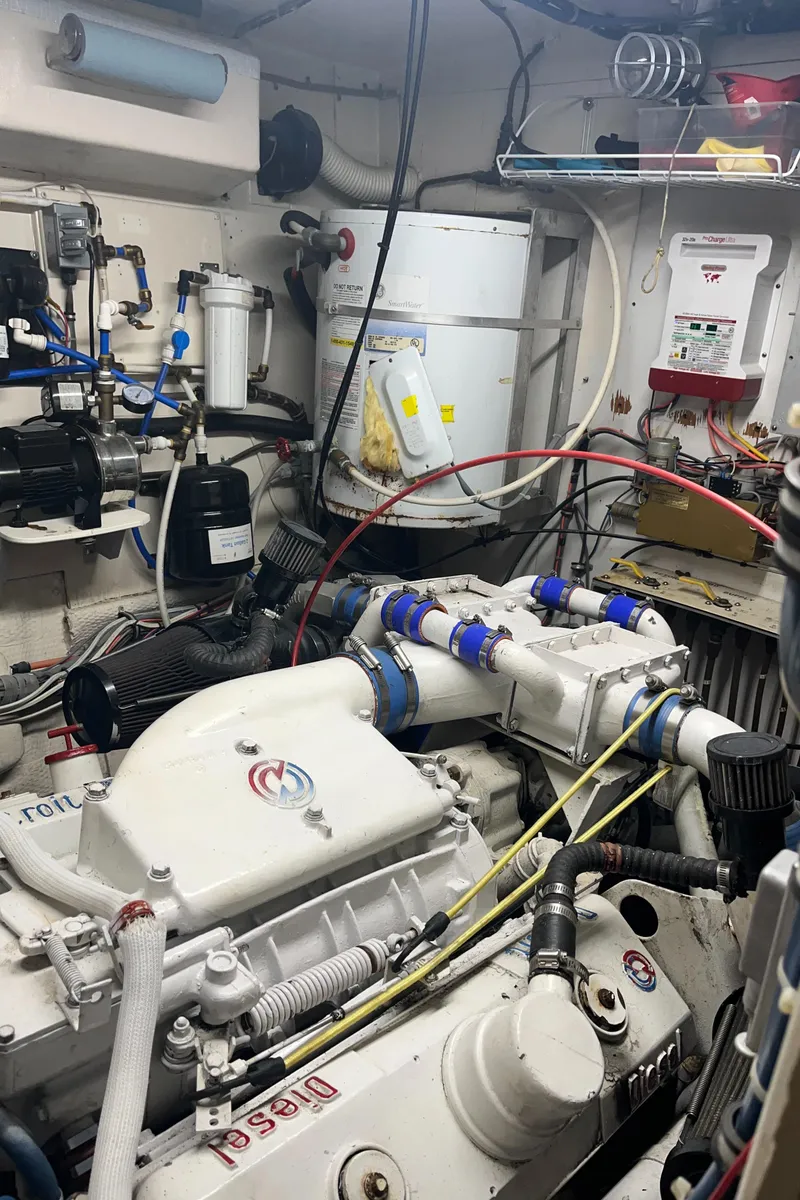 Slide: The Image of Engine room of a 1979 Hatteras 53 Motor Yacht with visible machinery and wiring. - 9