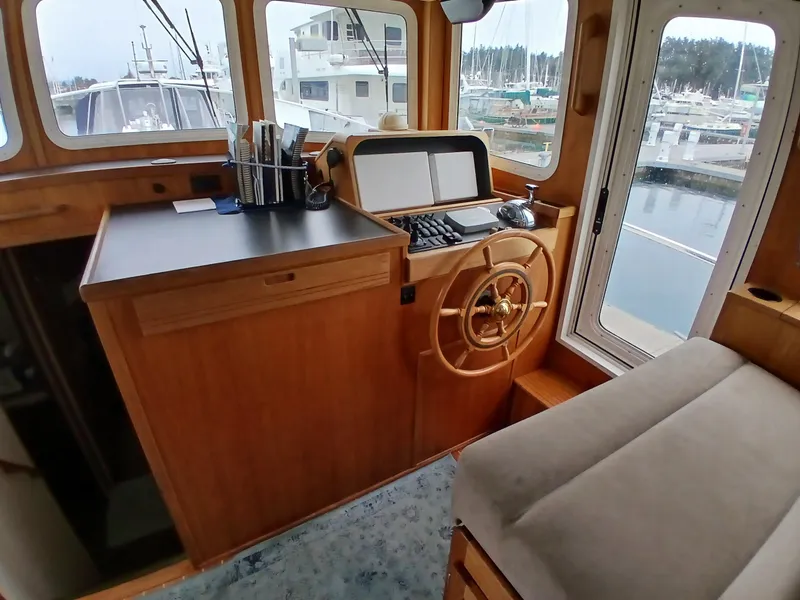 Slide: The Image of Nordic Tug 37 (2007) helm station with wooden interior and marina view. - 19