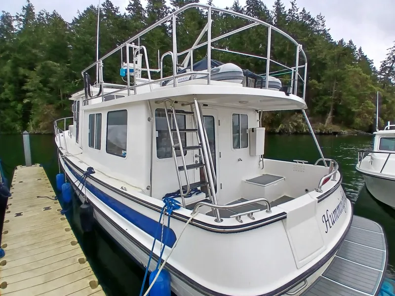 Slide: The Image of 2007 Nordic Tug 37 docked, featuring spacious deck and classic design. - 2