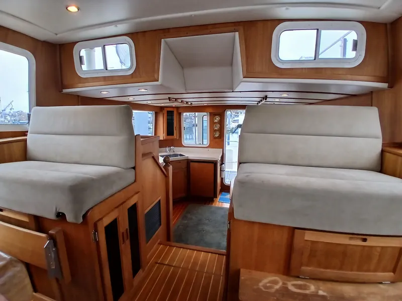 Slide: The Image of Interior of 2007 Nordic Tug 37, featuring wood paneling and cushioned seating. - 22