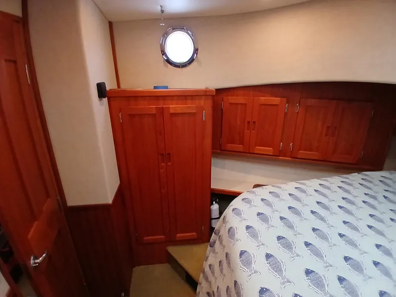 Slide: The Image of Cozy cabin interior of 2007 Nordic Tug 37 with wooden cabinetry and nautical-themed bedding. - 27