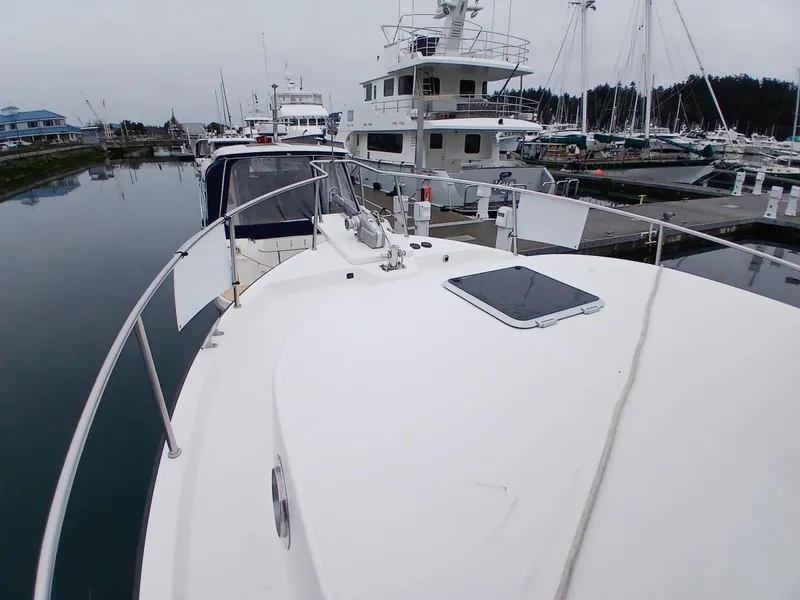 Slide: The Image of 2007 Nordic Tug 37 docked in a marina, showcasing its spacious deck and sleek design. - 5