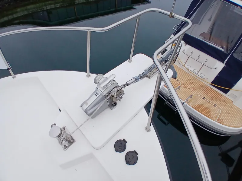 Slide: The Image of Nordic Tug 37 (2007) bow with anchor chain and railing, docked on calm water. - 6