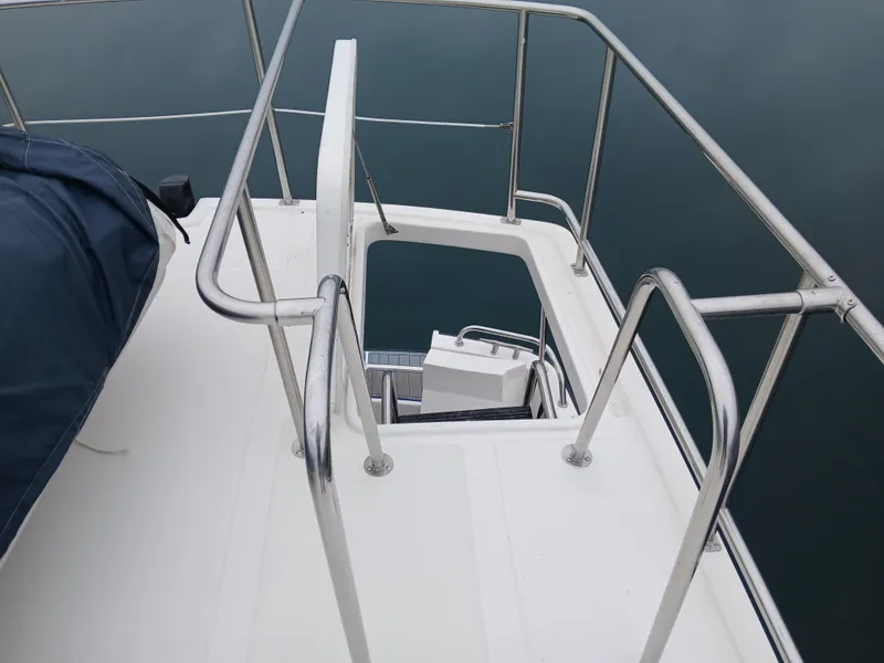 Slide: The Image of Nordic Tug 37 (2007) deck with stainless steel railings and hatch, overlooking water. - 9