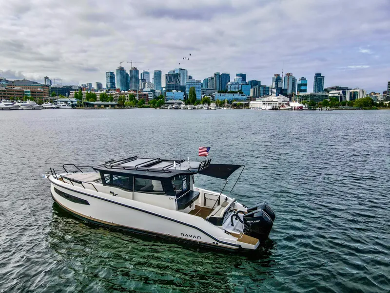 Slide: The Image of Navan C30 boat on water with city skyline, 2025 model. - 1