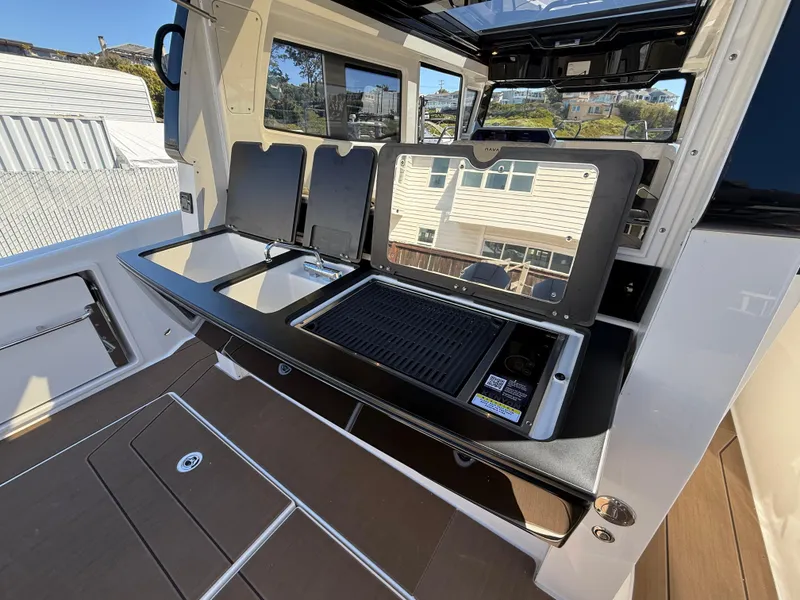 Slide: The Image of Outdoor kitchen on a 2025 Navan C30 boat with grill and storage compartments. - 13
