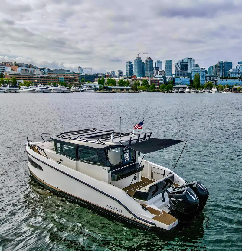 Slide: The Image of Navan C30 2025 boat on water with city skyline in background, overcast sky. - 3
