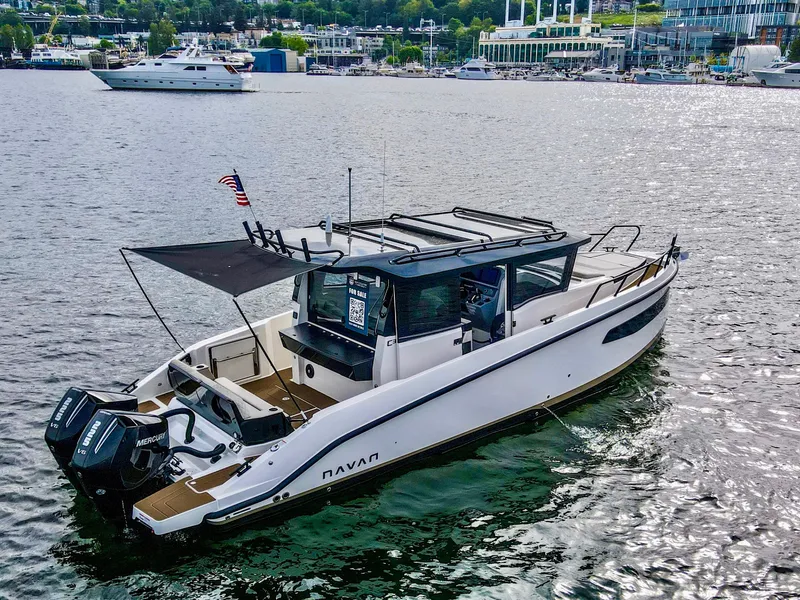 Slide: The Image of Navan C30 2025 boat cruising on a scenic lake with cityscape background. - 6