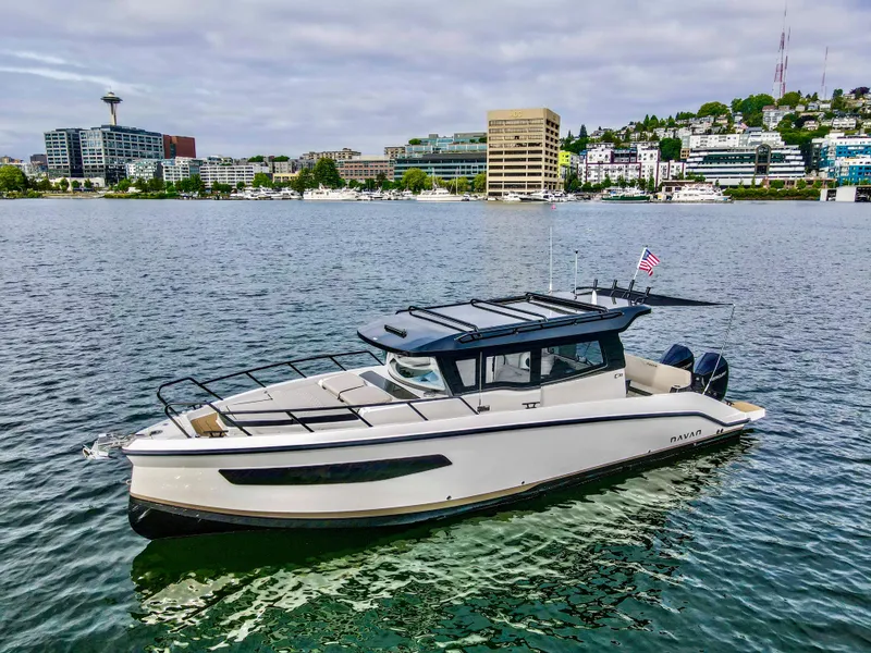 Slide: The Image of 2025 Navan C30 boat on a scenic urban waterfront with city skyline. - 7