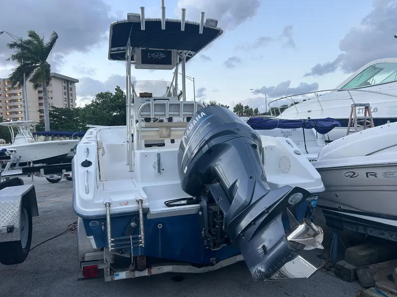 Slide: The Image of 2009 Cobia 216 Center Console boat with Yamaha outboard motor, docked in marina. - 2