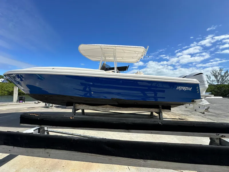 The Image of 2005 Intrepid 323 boat on trailer under clear blue sky. - 0