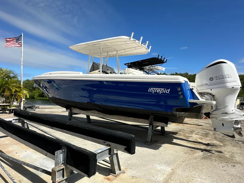 Slide: The Image of 2005 Intrepid 323 boat on trailer with Yamaha engine, American flag in background. - 1