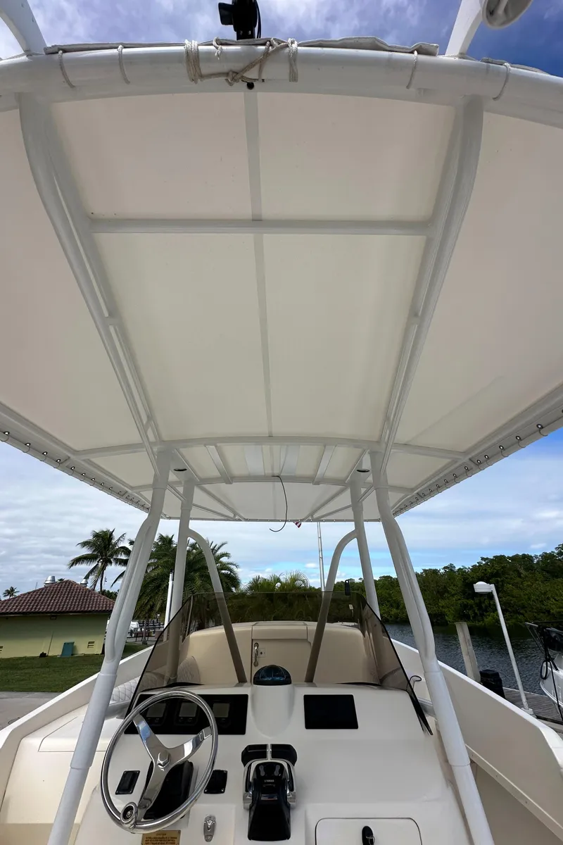 Slide: The Image of 2005 Intrepid 323 boat helm with canopy, steering wheel, and controls. - 23