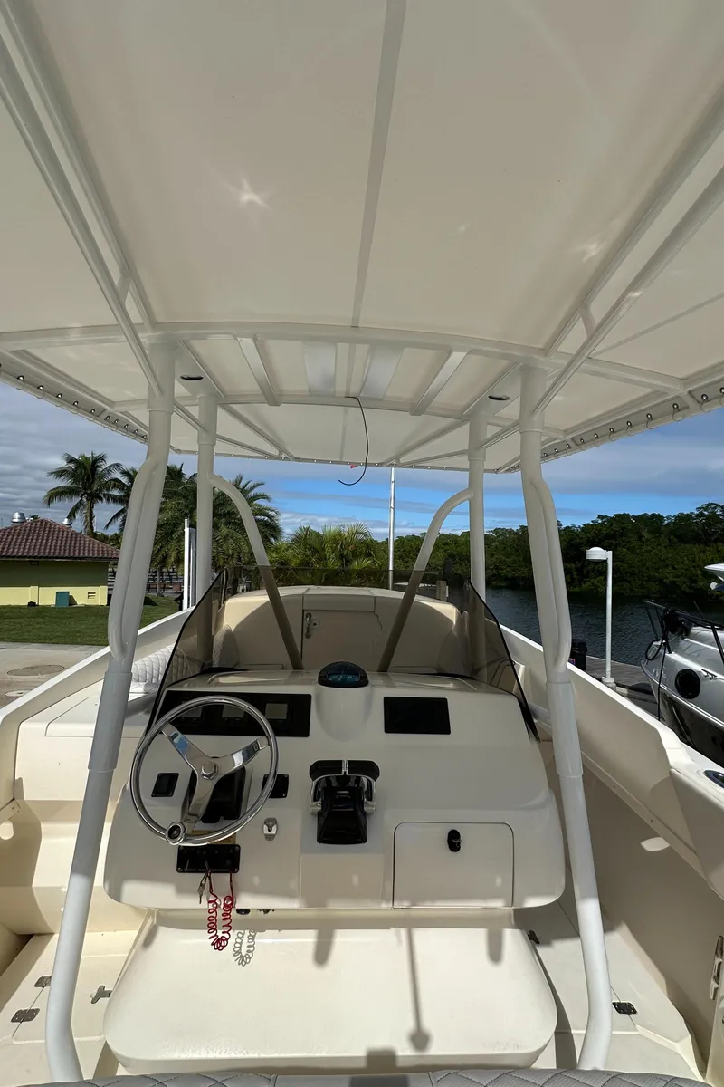 Slide: The Image of 2005 Intrepid 323 boat cockpit with steering wheel and controls, under a canopy. - 27