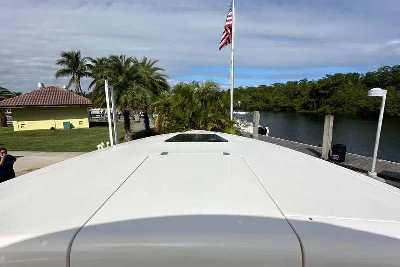 Slide: The Image of 2005 Intrepid 323 boat docked near palm trees and waterway. - 28