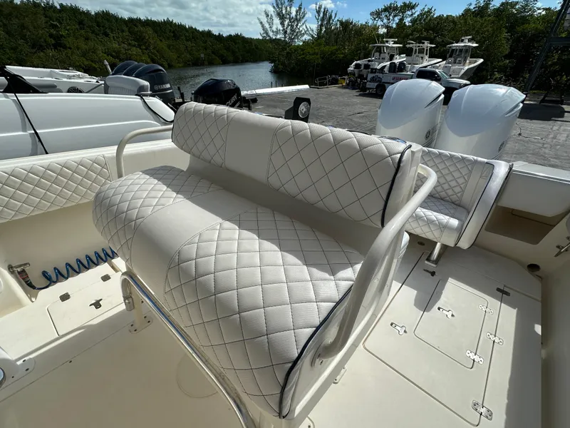 Slide: The Image of 2005 Intrepid 323 boat with quilted seating, docked near a river. - 9
