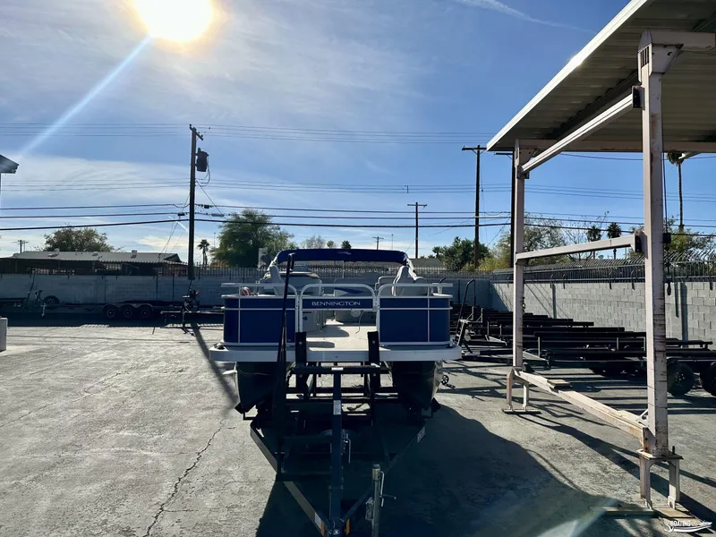 Slide: The Image of 2021 Bennington 20SV pontoon boat on trailer under sunny sky. - 1