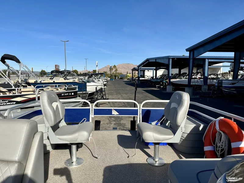 Slide: The Image of 2021 Bennington 20SV pontoon boat with seating, docked at a marina under clear skies. - 3