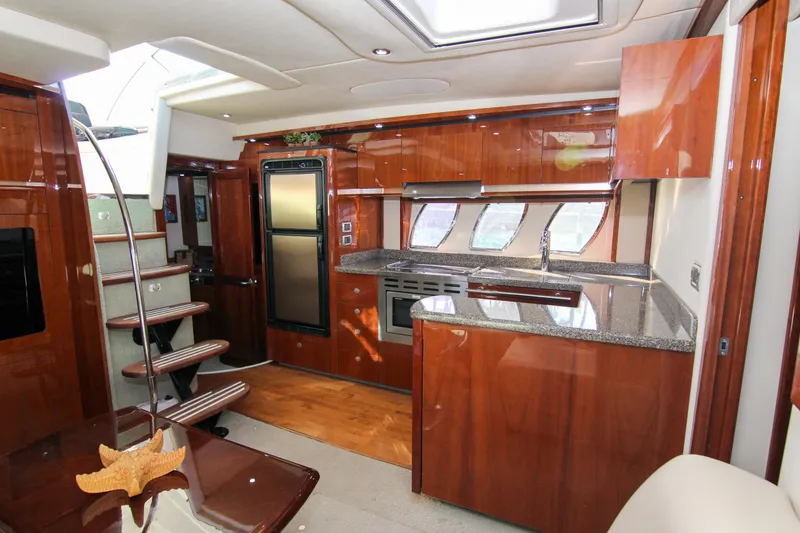 Slide: The Image of Luxurious interior of 2008 Sea Ray 48 Sundancer yacht with modern kitchen and wooden finishes. - 12