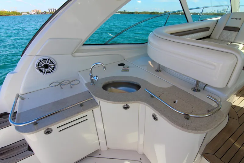 Slide: The Image of 2008 Sea Ray 48 Sundancer yacht interior with sink and seating, overlooking blue water. - 23