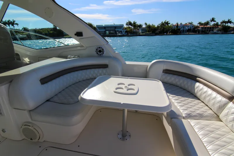 Slide: The Image of 2008 Sea Ray 48 Sundancer yacht interior with plush seating and table, overlooking serene water. - 24