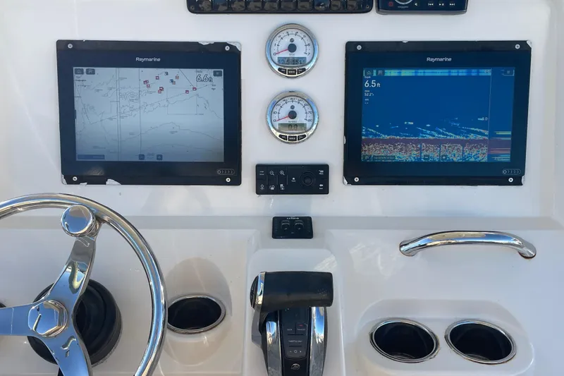 Slide: The Image of 2015 Sailfish 240 boat dashboard with navigation screens and controls. - 14