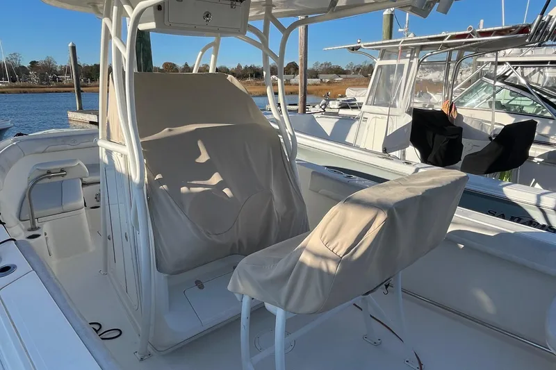 Slide: The Image of 2015 Sailfish 240 boat interior with covered seats, docked at marina. - 19
