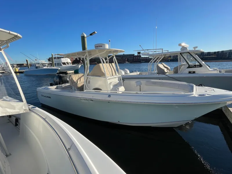 Slide: The Image of 2015 Sailfish 240 boat docked in a marina under clear blue skies. - 3