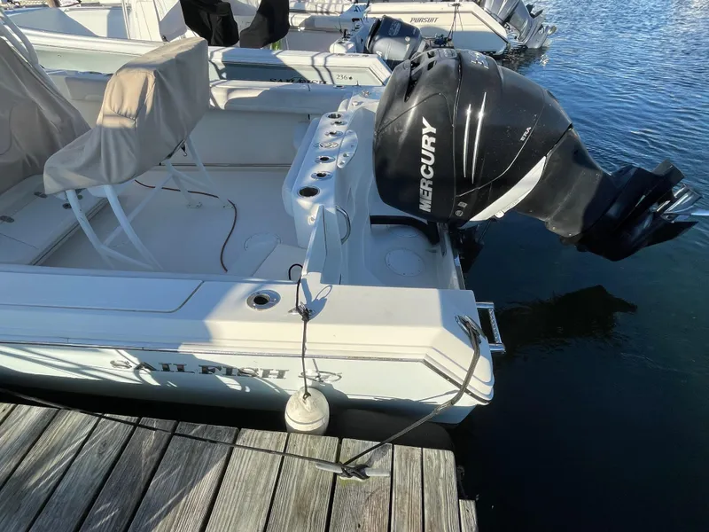 Slide: The Image of 2015 Sailfish 240 boat with Mercury outboard motor docked at marina. - 4