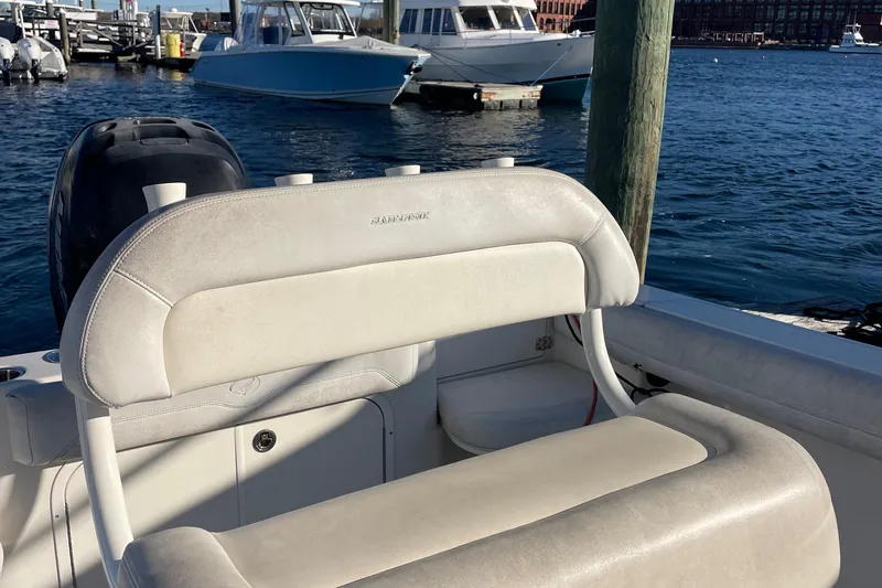 Slide: The Image of Sailfish 240 boat interior with white seating, docked near other boats, 2015 model. - 8