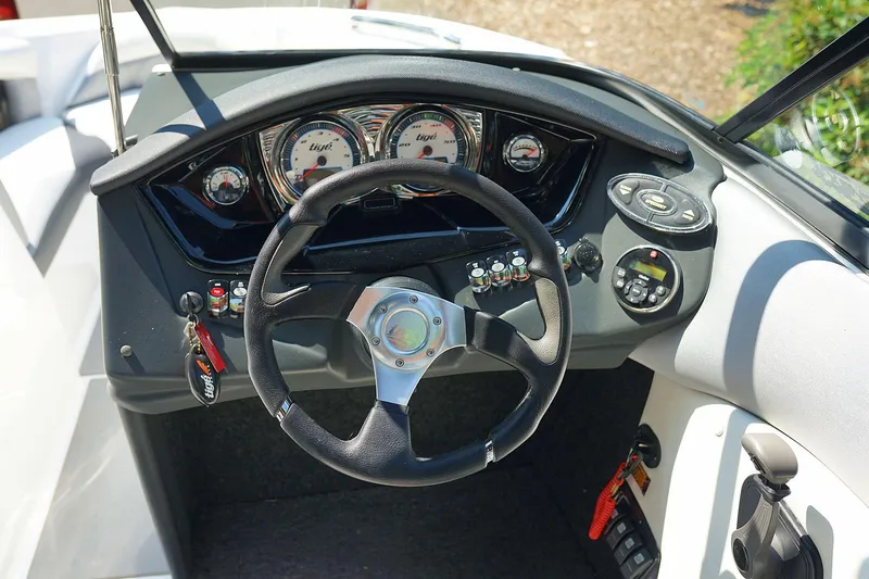 Slide: The Image of 2014 Tigé R20 boat dashboard with steering wheel and gauges. - 12