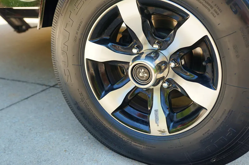 Slide: The Image of Close-up of a 2014 Tigé R20 boat trailer wheel on concrete. - 21
