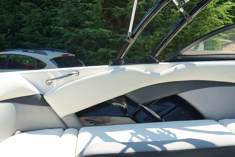 Slide: The Image of Interior of 2014 Tigé R20 boat with white and gray seating, near trees. - 29