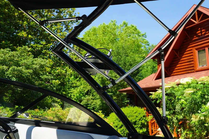 Slide: The Image of 2014 Tigé R20 boat with wakeboard tower near a wooden cabin. - 7