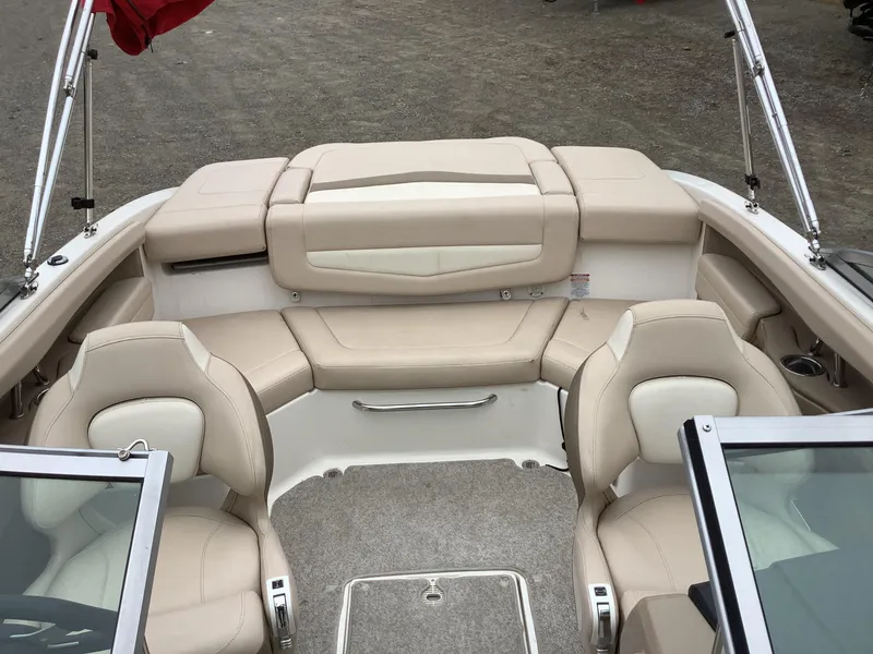 Slide: The Image of 2012 Chaparral 216 SSi boat interior with beige seating and carpeted floor. - 14
