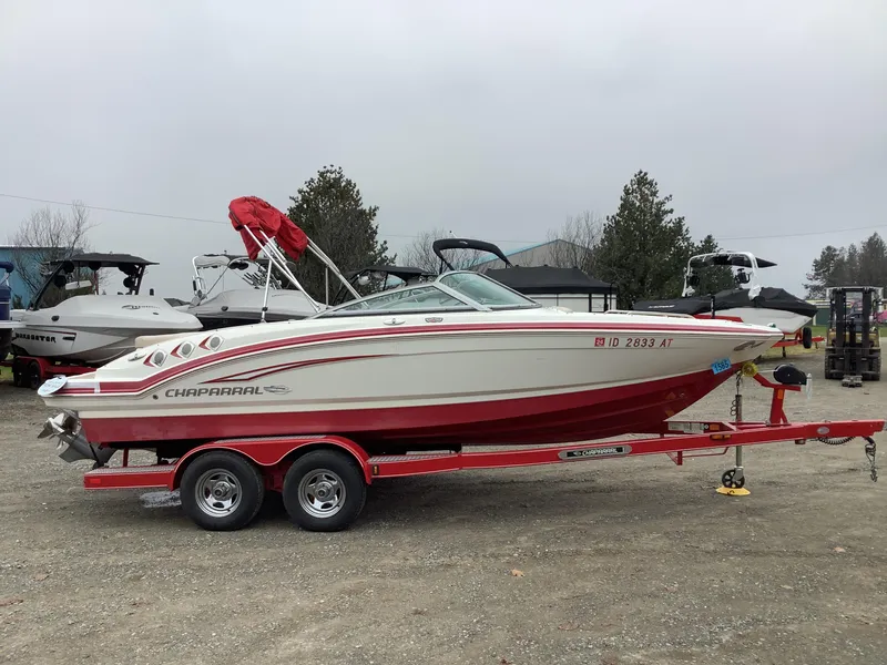 Slide: The Image of 2012 Chaparral 216 SSi boat on red trailer, parked outdoors. - 5