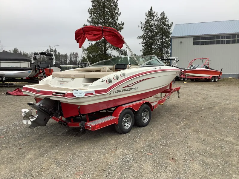 Slide: The Image of 2012 Chaparral 216 SSi boat on red trailer, parked outdoors. - 6
