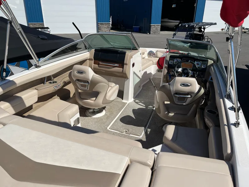 Slide: The Image of 2012 Chaparral 216 SSi boat interior with beige seating and modern dashboard. - 9