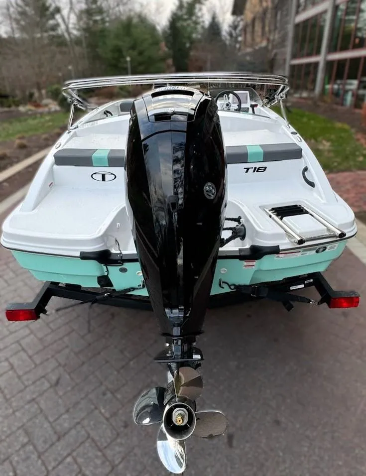 Slide: The Image of 2025 Tahoe T18 boat with outboard motor, parked on a paved driveway. - 3