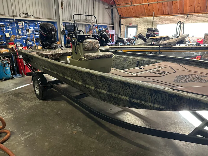 Slide: The Image of 2025 Tracker Grizzly 1860 CC boat in a workshop setting. - 2