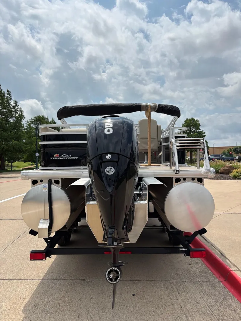 Slide: The Image of 2025 Sun Tracker Sportfish 24 XP3 pontoon boat interior with beige seating and steering console. - 3