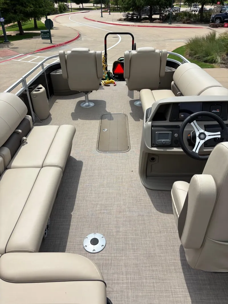 Slide: The Image of 2025 Sun Tracker Sportfish 24 XP3 boat interior with steering wheel and seating. - 4