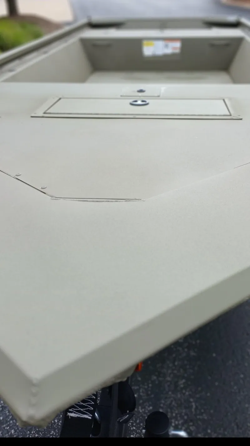 Slide: The Image of 2025 Tracker Grizzly 1648 Jon boat, front view, showcasing sleek design and storage compartment. - 15