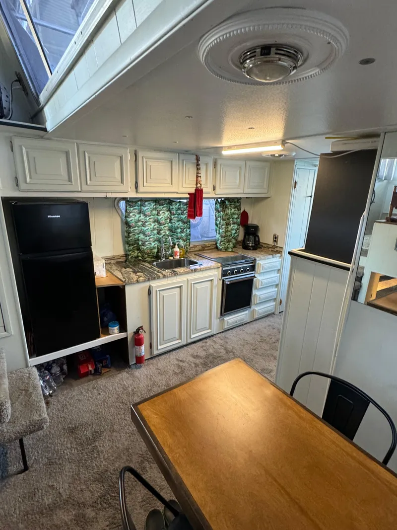 Slide: The Image of 1979 Nauta-Line Nautaline kitchen interior with white cabinets, black fridge, and wooden dining table. - 10
