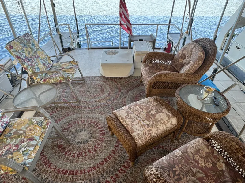 Slide: The Image of 1979 Nauta-Line Nautaline boat deck with wicker furniture and floral cushions, overlooking water. - 19