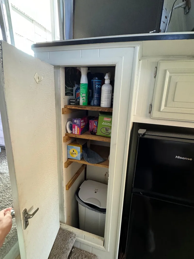 Slide: The Image of 1979 Nauta-Line Nautaline interior cabinet with cleaning supplies and a Hisense fridge. - 7